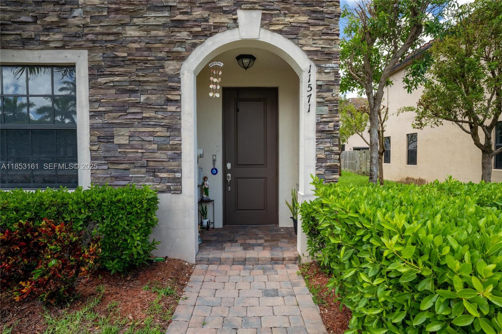 11571 Southwest 248th Lane Homestead, FL 33032 - Photo 2 of 26 a view of a brick house with potted plants