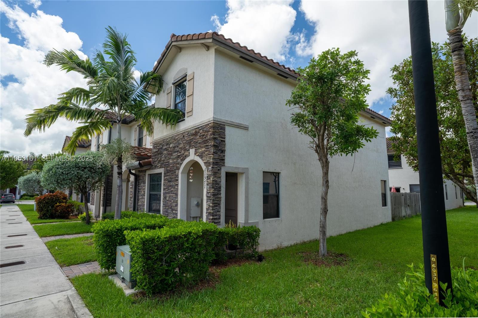 11571 Southwest 248th Lane Homestead, FL 33032 - Photo 3 of 26 a front view of a house with a garden
