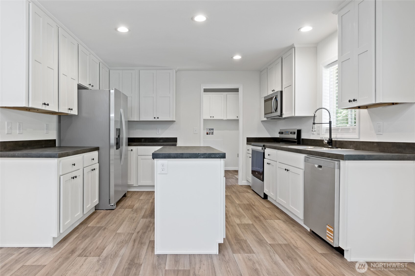 17217 80th Street Southwest Longbranch, WA 98351 - Photo 14 of 39 a kitchen with white cabinets sink and stainless steel appliances