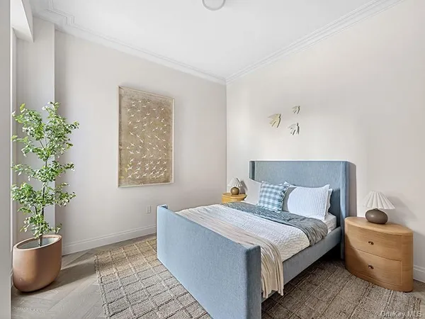 a bedroom with a bed and a potted plant