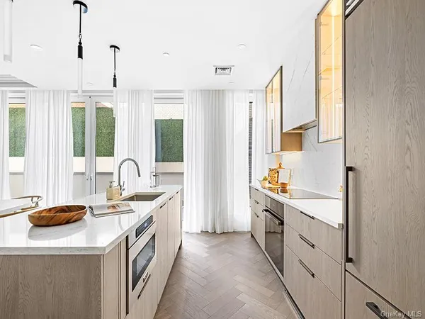 a kitchen with white cabinets and sink