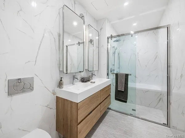 a bathroom with a double vanity sink mirror and shower