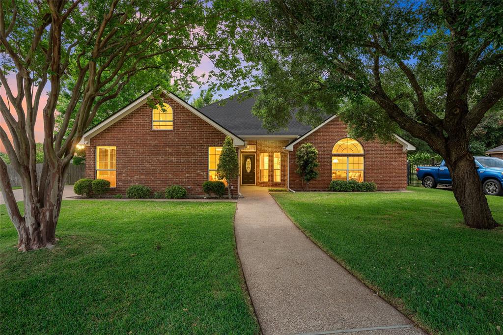 View of front of home featuring brick siding and a yard