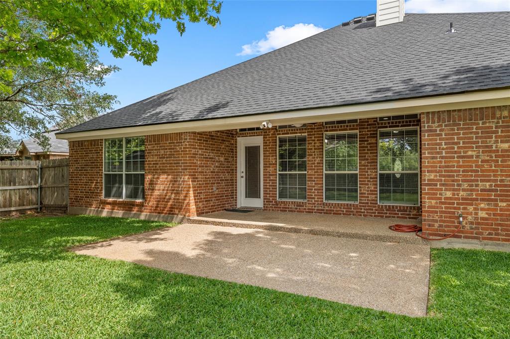 940 Cheyenne Trail Hewitt, TX 76643 - Photo 27 of 40 Rear view of property with a patio, a shingled roof, a chimney, and brick siding