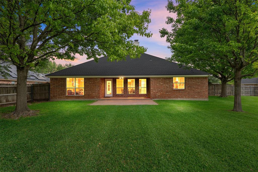 940 Cheyenne Trail Hewitt, TX 76643 - Photo 28 of 40 Rear view of house with a fenced backyard, a chimney, a patio area, and brick siding