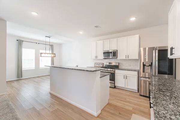 a kitchen with stainless steel appliances granite countertop a refrigerator sink and cabinets