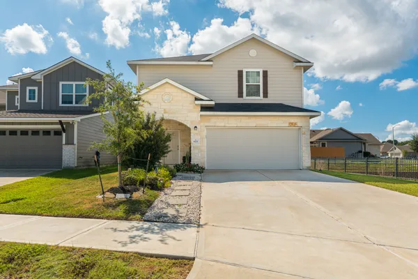 a front view of a house with a yard and garage