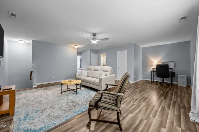 a living room with furniture and a wooden floor