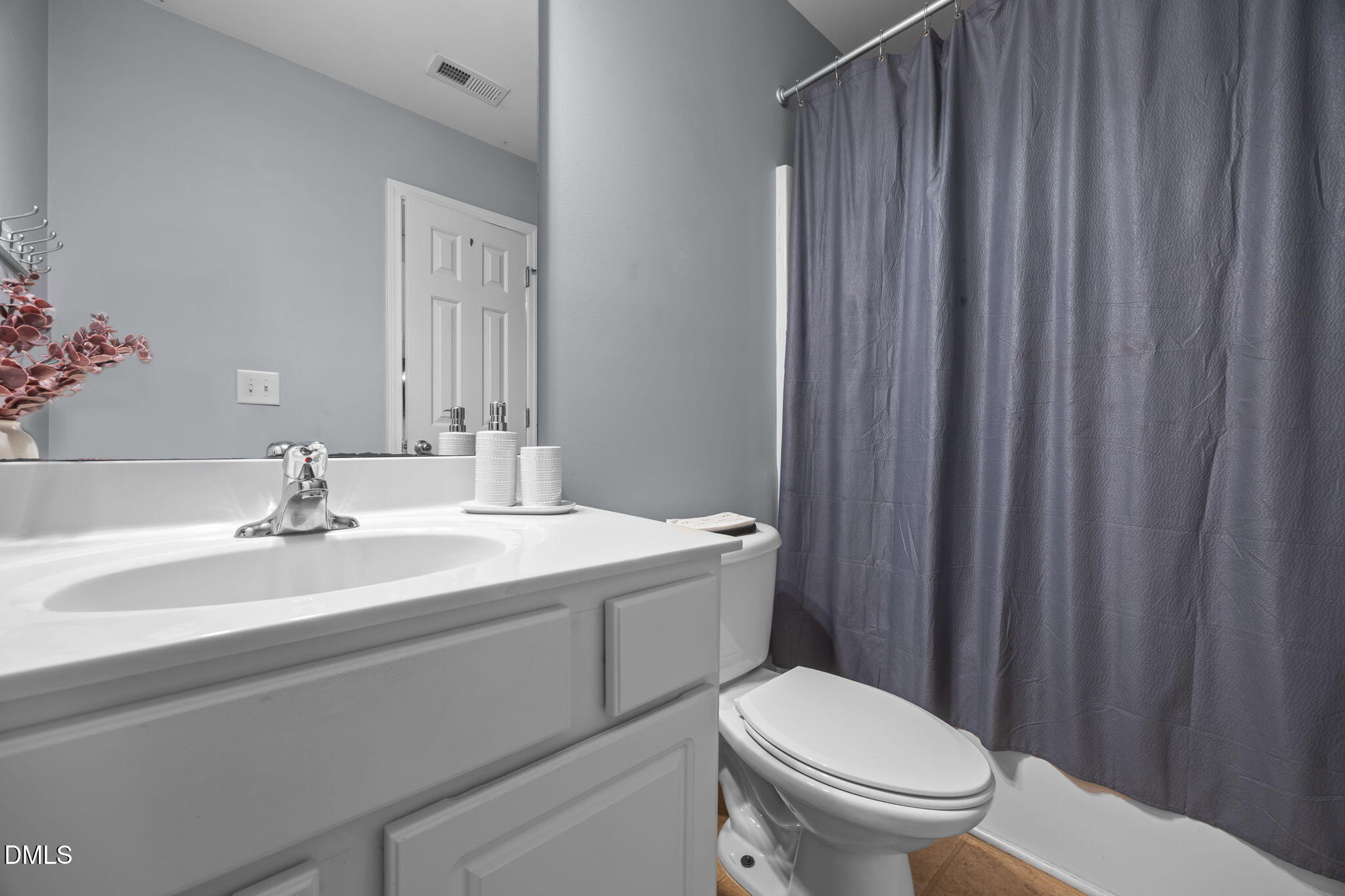 153 Deacon Ridge Street Wake Forest, NC 27587 - Photo 26 of 34 a bathroom with a toilet a sink and a mirror