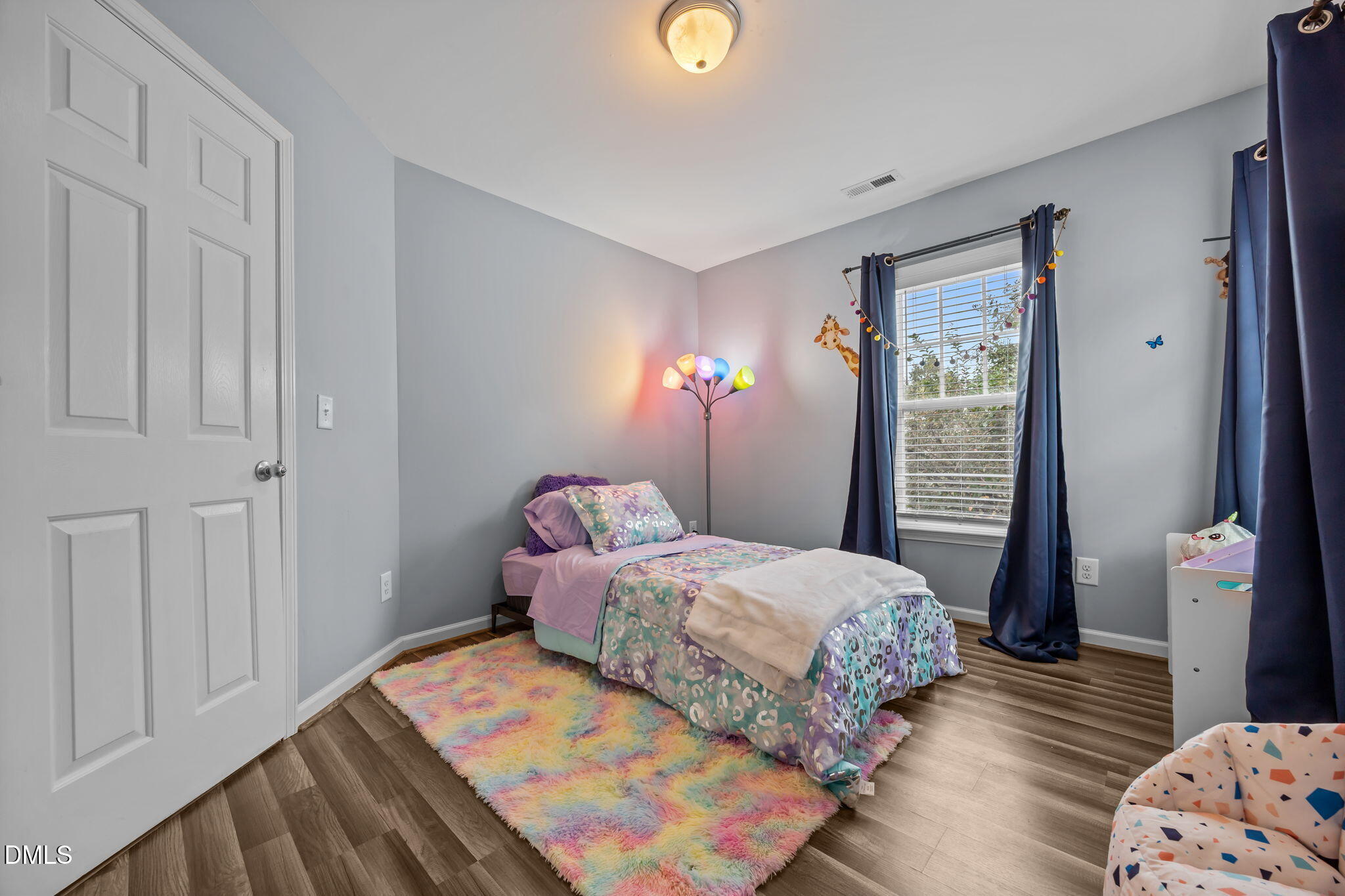 153 Deacon Ridge Street Wake Forest, NC 27587 - Photo 27 of 34 a bedroom with a bed and wooden floor