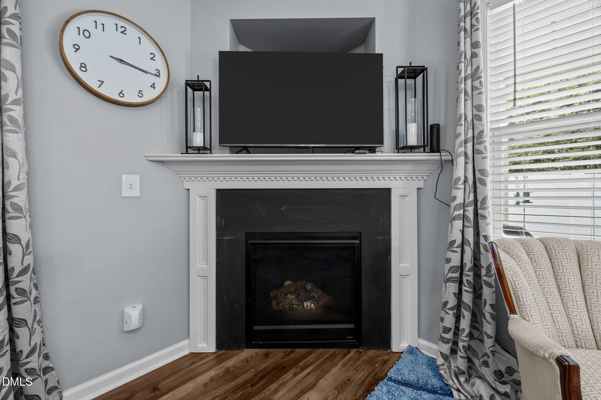 153 Deacon Ridge Street Wake Forest, NC 27587 - Photo 6 of 34 a living room with a fireplace and a clock