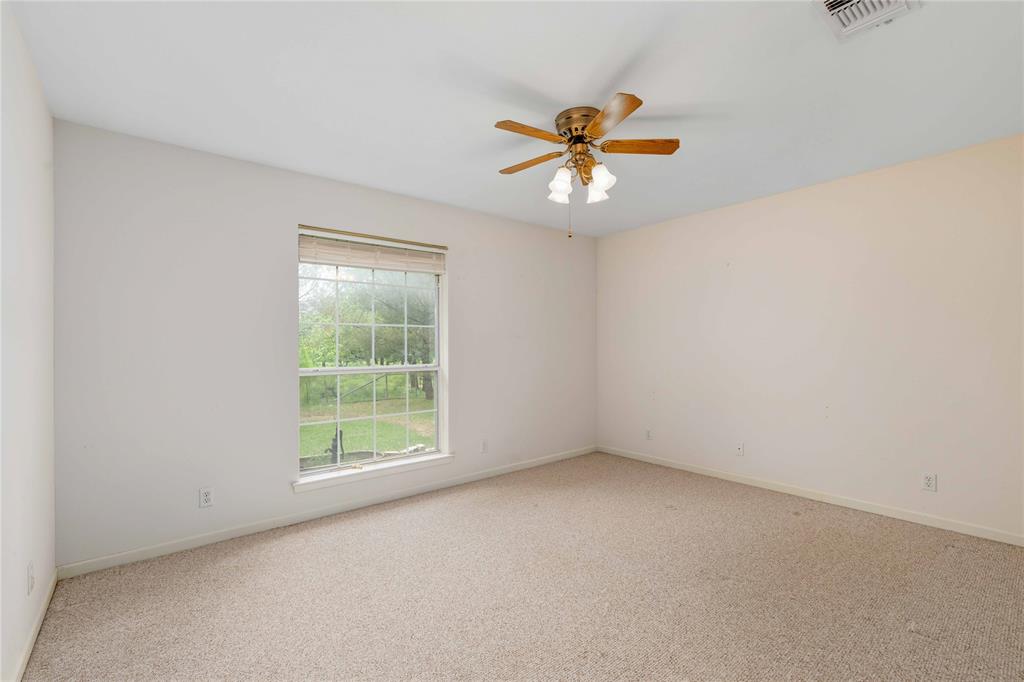 4300 County Road 372 Early, TX 76802 - Photo 23 of 40 an empty room with a window and a fan