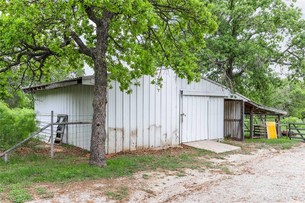 4300 County Road 372 Early, TX 76802 - Photo 33 of 40 a backyard of a house with lawn chairs plants and large tree