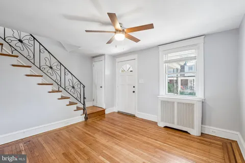 a view of an entryway with wooden floor and a chandelier fan