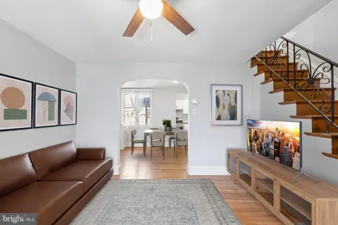 a open kitchen with stainless steel appliances granite countertop a stove top oven a sink a dining table and chairs with wooden floor