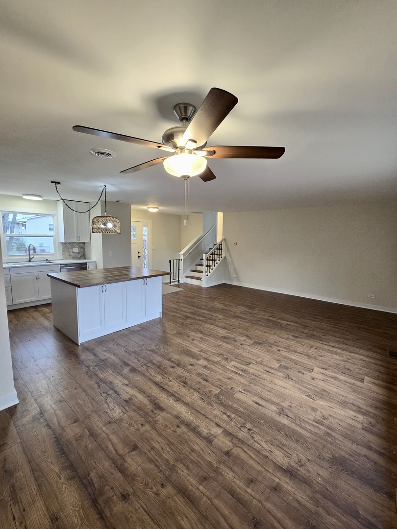 1010 Ridgewood Drive Bolingbrook, IL 60440 - Photo 11 of 29 a view of an empty room with a kitchen and wooden floor