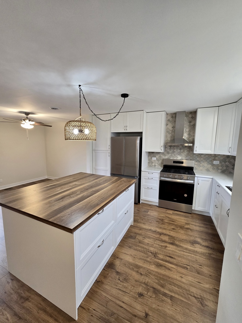 1010 Ridgewood Drive Bolingbrook, IL 60440 - Photo 6 of 29 a large kitchen with cabinets wooden floor and stainless steel appliances