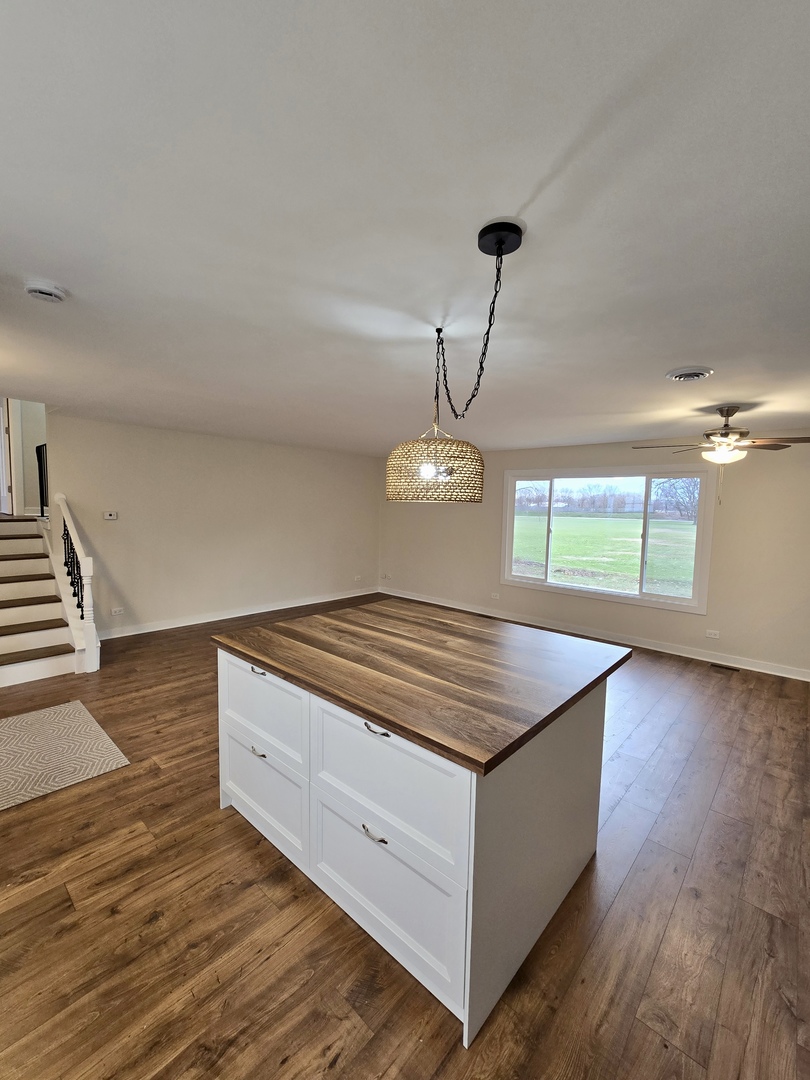 1010 Ridgewood Drive Bolingbrook, IL 60440 - Photo 10 of 29 a kitchen with kitchen island stainless steel appliances a wooden floor a stove and a wooden floor