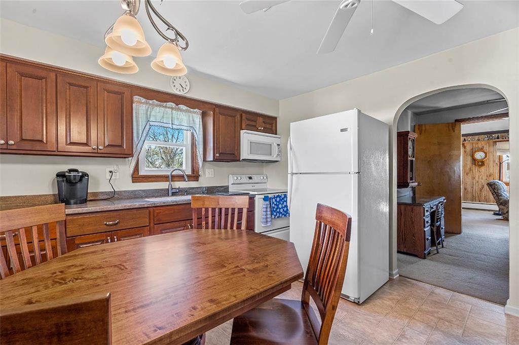 120 Township Line Road Butler, PA 16002 - Photo 11 of 25 a kitchen with stainless steel appliances granite countertop a refrigerator a stove a sink a dining table and chairs with wooden floor