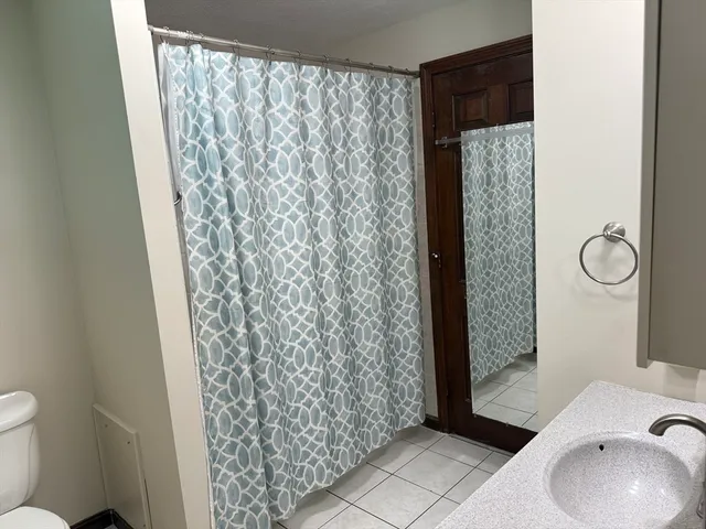 a bathroom with a toilet and a shower curtain