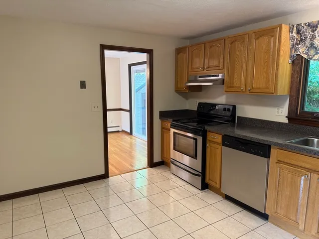 a kitchen with granite countertop a stove a sink and a microwave