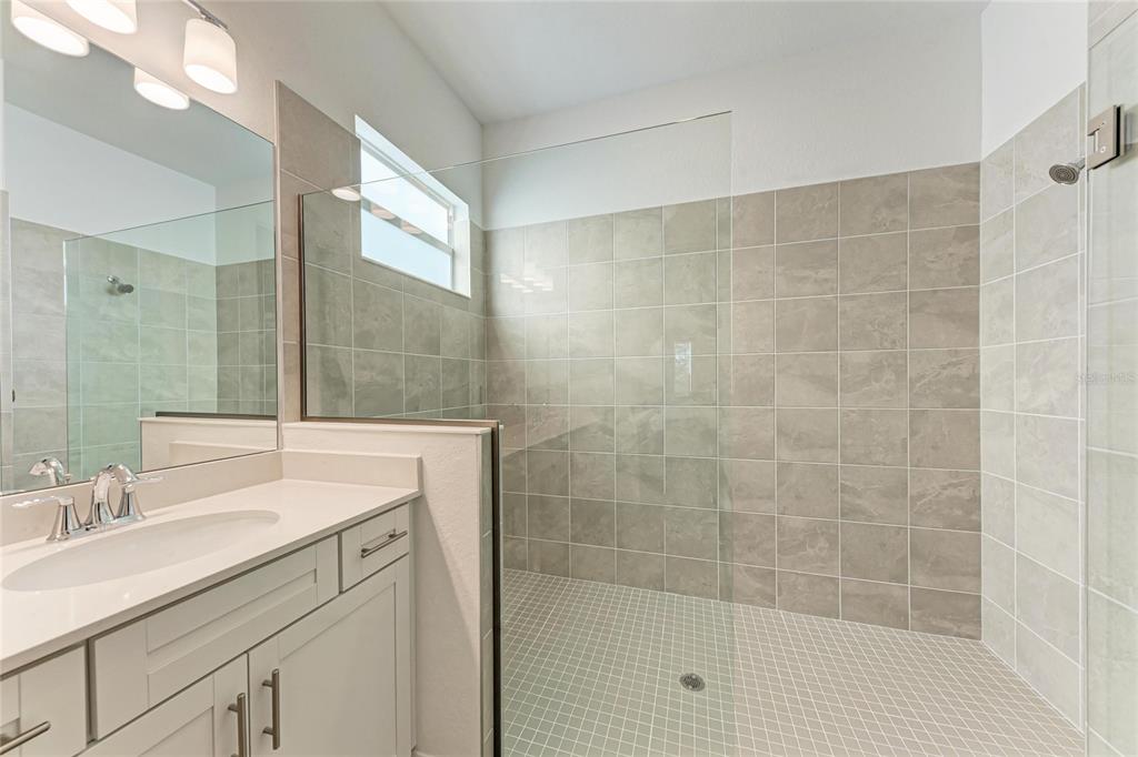 13021 Tulum Loop Venice, FL 34293 - Photo 17 of 66 a bathroom with a sink shower and a mirror