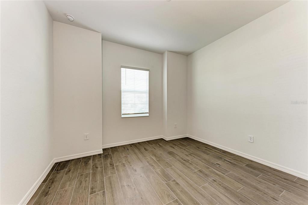 13021 Tulum Loop Venice, FL 34293 - Photo 20 of 66 an empty room with wooden floor and windows