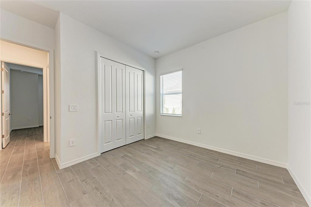 13021 Tulum Loop Venice, FL 34293 - Photo 22 of 66 an empty room with wooden floor and windows