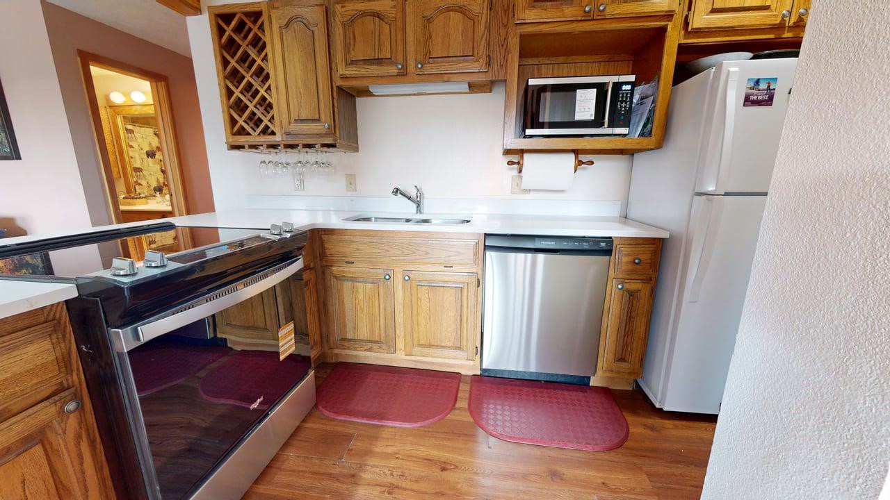 91200 Ryan Gulch Road, Unit 213 Silverthorne, CO 80498 - Photo 9 of 33 a kitchen with a sink and a refrigerator