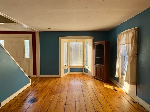 a view of a livingroom with wooden floor and front door