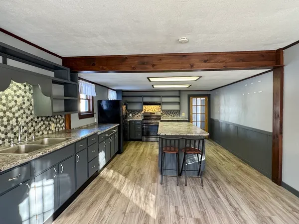 a kitchen with stainless steel appliances wooden floors stove and cabinets