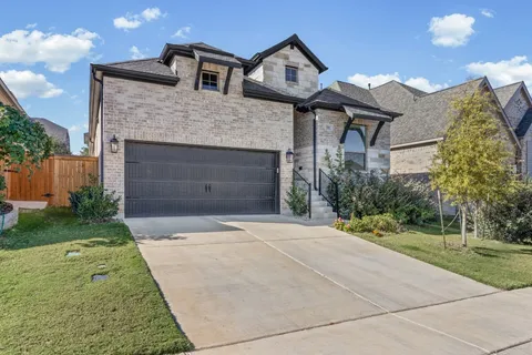 a front view of a house with a garden and garage