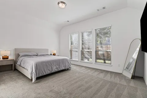 a spacious bedroom with a bed and a large window