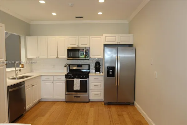 a kitchen with a sink stainless steel appliances and cabinets