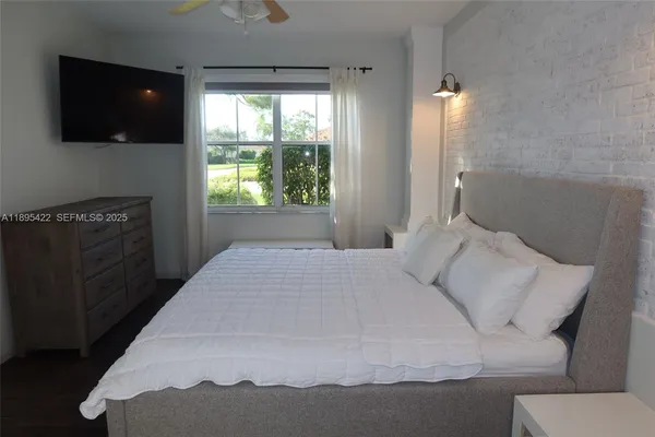 a bedroom with a bed and a flat screen tv