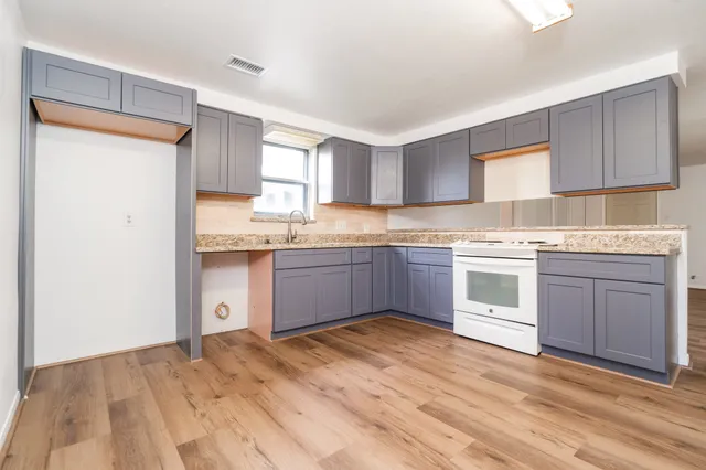 a kitchen with stainless steel appliances granite countertop a stove a sink dishwasher and a refrigerator