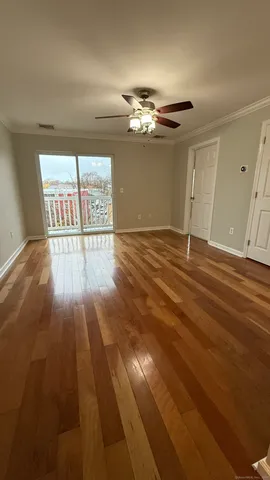 a view of empty room with wooden floor
