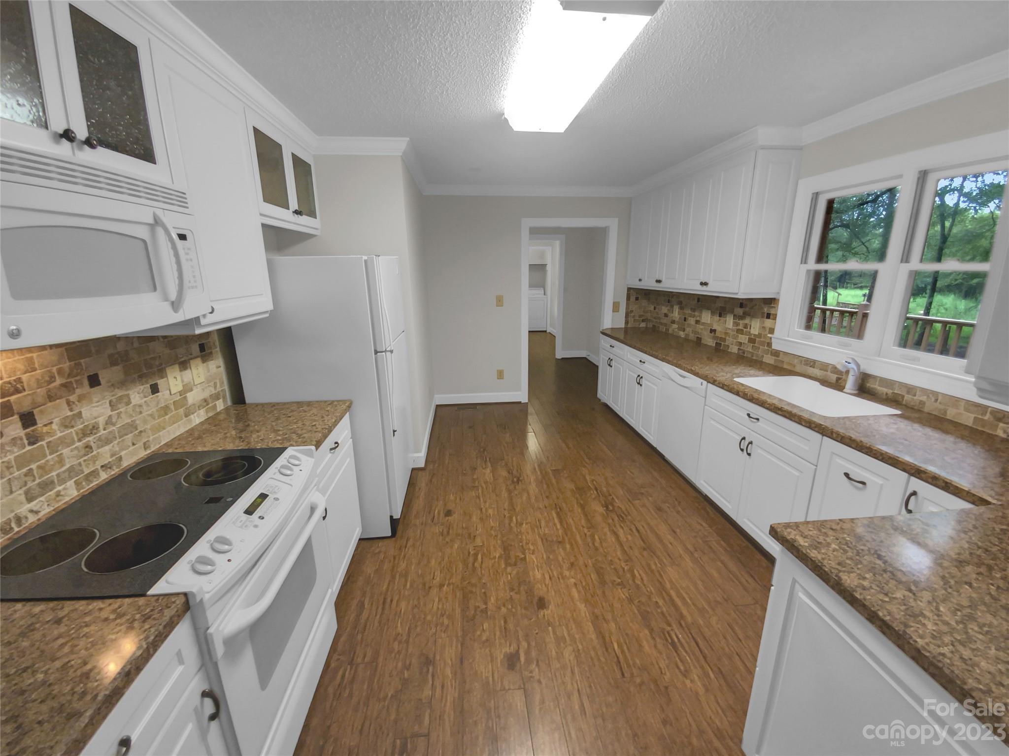 3618 Griffith Road Monroe, NC 28112 - Photo 9 of 16 a kitchen with a stove a sink and a refrigerator