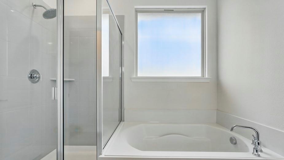 4162 Waldron Trail Forney, TX 75126 - Photo 19 of 29 Full bathroom featuring a built-in soaking tub with chrome fixtures, a shower enclosure with a glass door, a rain showerhead, and white tiled walls