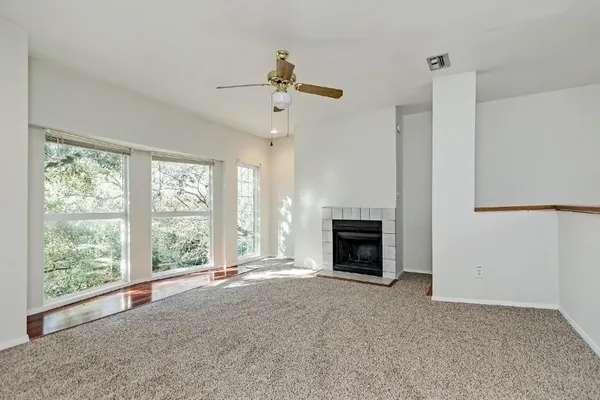 a view of an empty room with a fireplace and a window