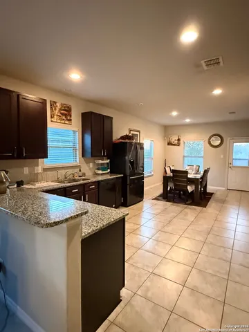 a kitchen with granite countertop a sink a counter top space appliances and cabinets