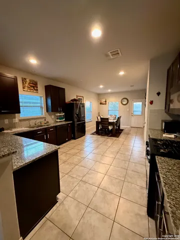 a kitchen with a sink a counter top space appliances and cabinets