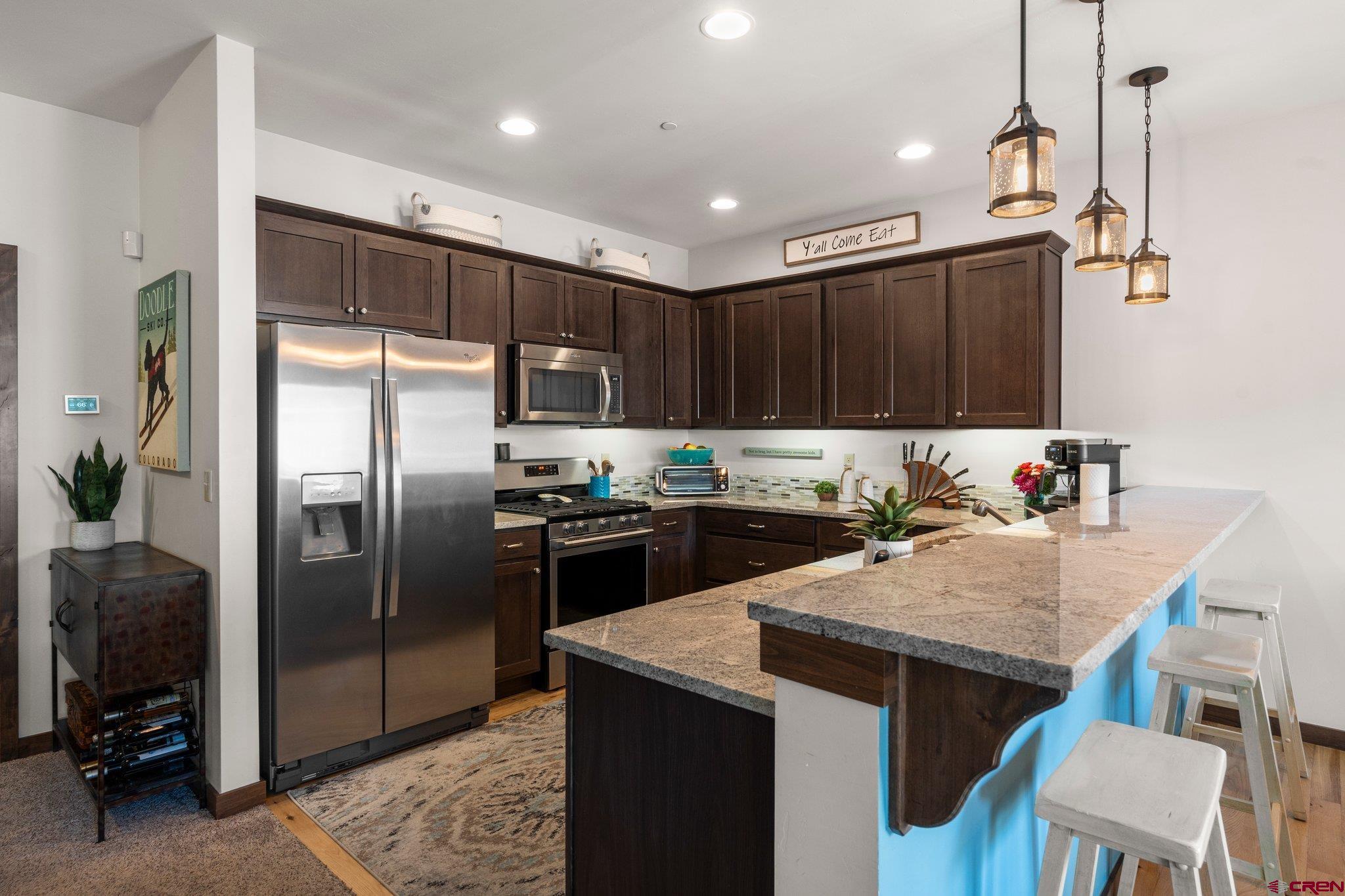 1422 Animas View Drive, Unit 25 Durango, CO 81301 - Photo 2 of 35 a kitchen with kitchen island a counter top space a sink stainless steel appliances and cabinets