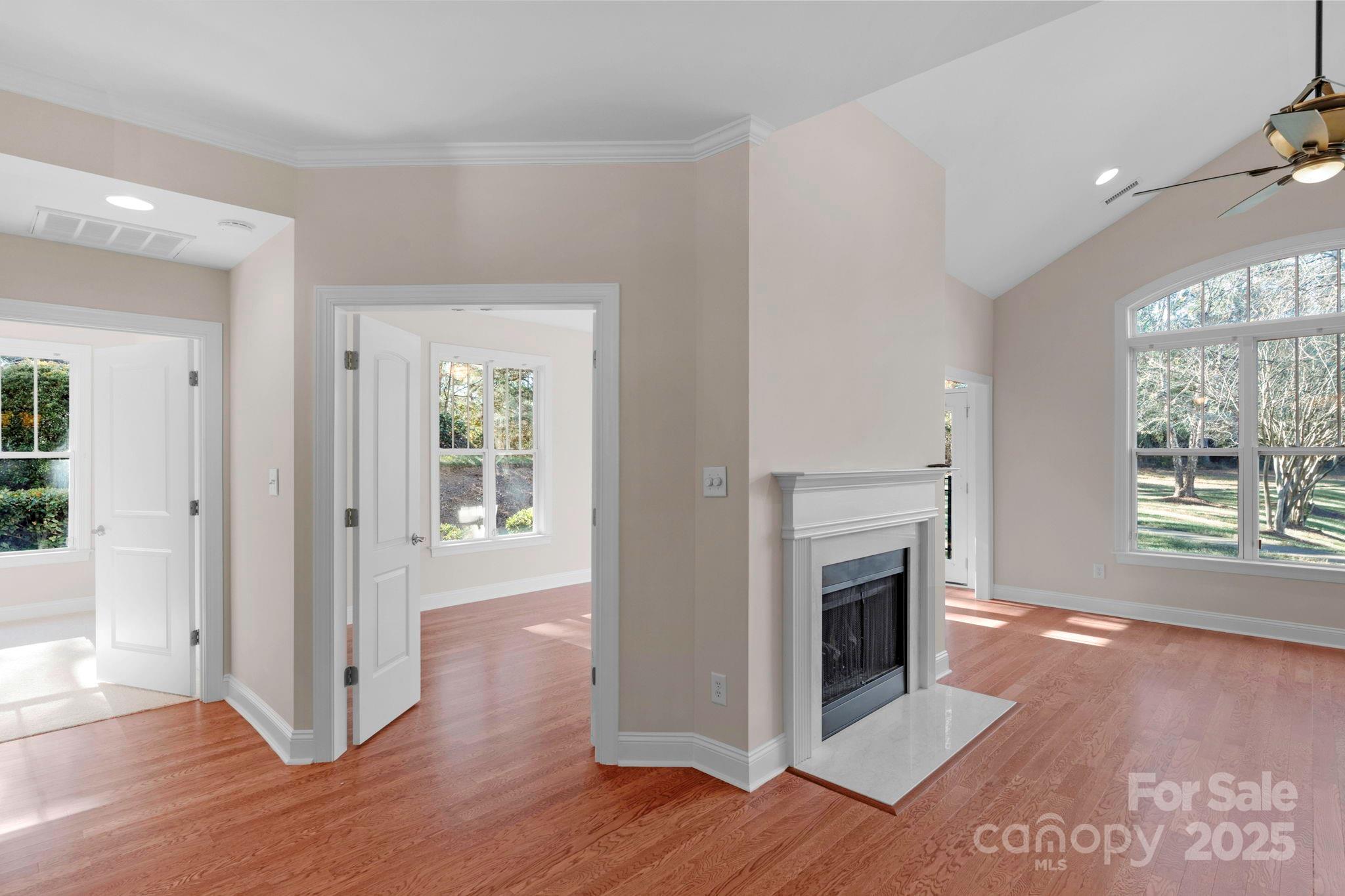 3038 Bellasera Way Matthews, NC 28105 - Photo 17 of 43 an empty room with wooden floor fireplace and windows