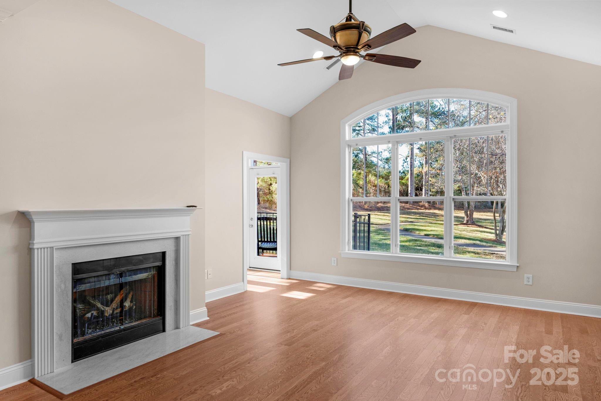 3038 Bellasera Way Matthews, NC 28105 - Photo 4 of 43 a view of an empty room with wooden floor fireplace and a window