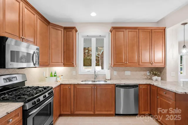 a kitchen with granite countertop a sink stove and cabinets
