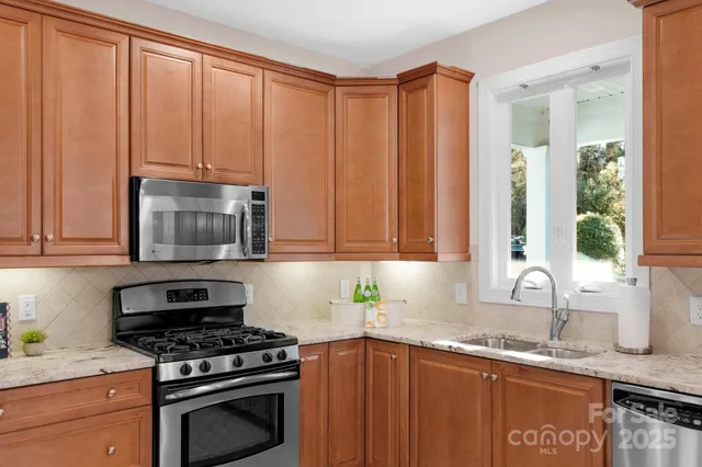 a kitchen with granite countertop a sink a stove and cabinets