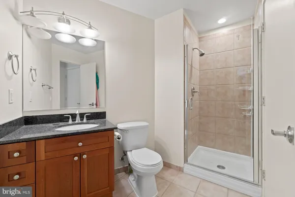 a bathroom with a granite countertop sink toilet and shower