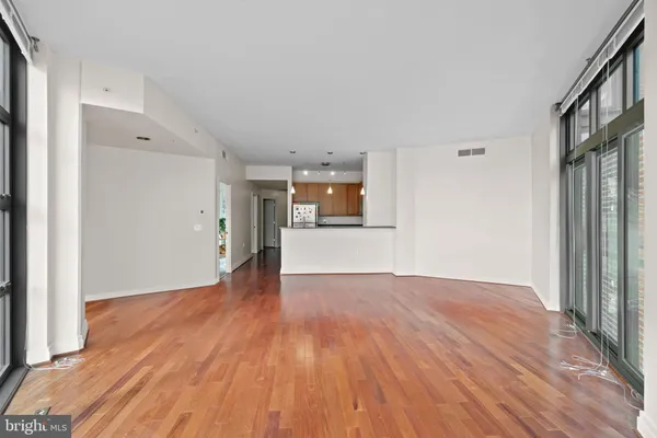 a view of a big room with wooden floor and windows