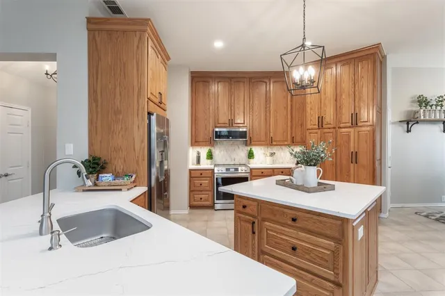 a kitchen with granite countertop a sink stainless steel appliances and cabinets